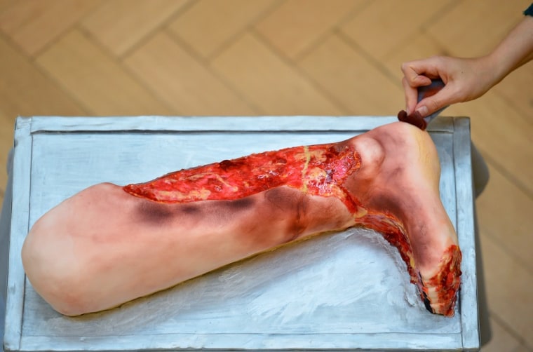 A baker puts the finishing touches to a cake depicting an injured leg on Oct. 25.