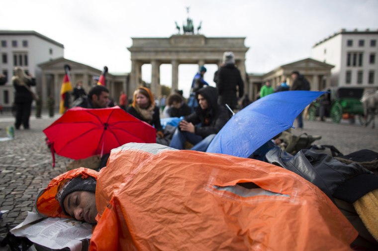 An Iranian refugee sleeps in front of Brandenburg Gate during a hunger strike in Berlin Oct. 25. Some 20 refugees, mainly from Iran and Afghanistan, went on hunger strike on Oct. 24 demanding an end to deportations, obligatory camp accommodation to be abolished and restrictions on their movements be lifted, the refugees said. They are part of a larger group of asylum seekers who have marched some 372 miles from the southern town of Wuerzburg to the German capital.