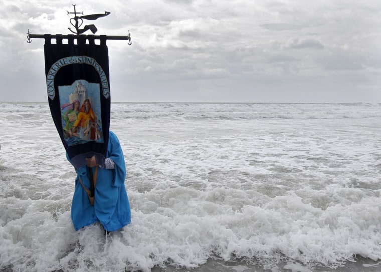 A pilgrim carries a flag of the 'Saintes Maries' Brotherhood.