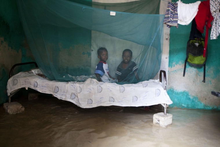 Children sit on a cot inside their flooded home caused by heavy rains from Hurricane Sandy in Port-au-Prince, Haiti, Oct. 25.
