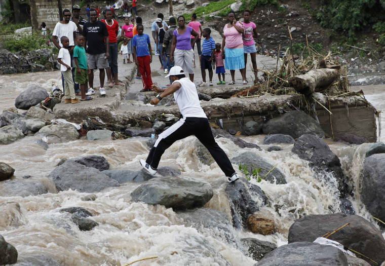 Residents of Kingston try to cross the Hope River after a bridge was washed out by Hurricane Sandy, on Oct. 25.
