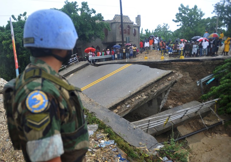 A UN Peacekeeper stands watch near a bridge washed away by heavy rains from Hurricane Sandy on Oct. 25 in Port-au-Prince, Haiti.