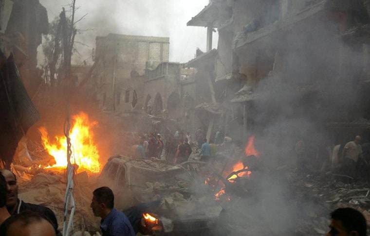 A handout picture released by the Syrian Revolution General Commission shows Syrians inspecting the site of a car bomb attack in the Daf Shawk district of Damascus on Oct. 26. At least five people were killed and 32 wounded in a car bomb attack in southern Damascus, Syrian state television said, while the Syrian Observatory for Human Rights said children were among the wounded.