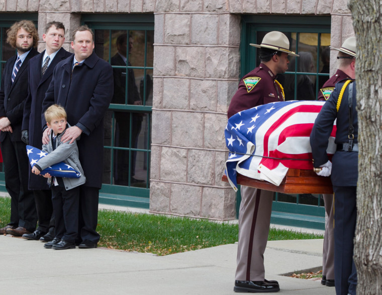 Will Mead holds a tri-folded flag as he watches with family members the casket of his great grandfather, former Democratic U.S. Senator and three-time presidential candidate George McGovern, being carried into the Washington Pavilion of Arts and Science in Sioux Falls, S.D., for the funeral service, on Oct. 26. McGovern died Sunday in his native South Dakota at age 90.