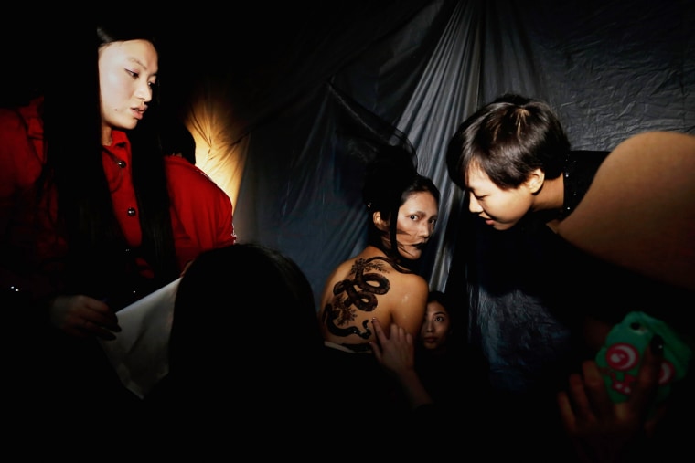 A model receives final touches to her outfit during the SEC Qi Gang Collection of China Fashion Week in Beijing, Oct. 26.