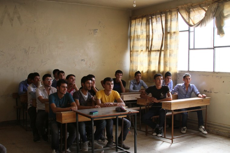 High school students in a classroom in Derik, Syria, listen to a teacher giving Kurdish lessons. Teaching the Kurdish language was previously forbidden.