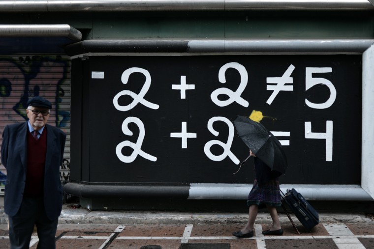 A woman walks past graffiti in the center of Athens on October 23.