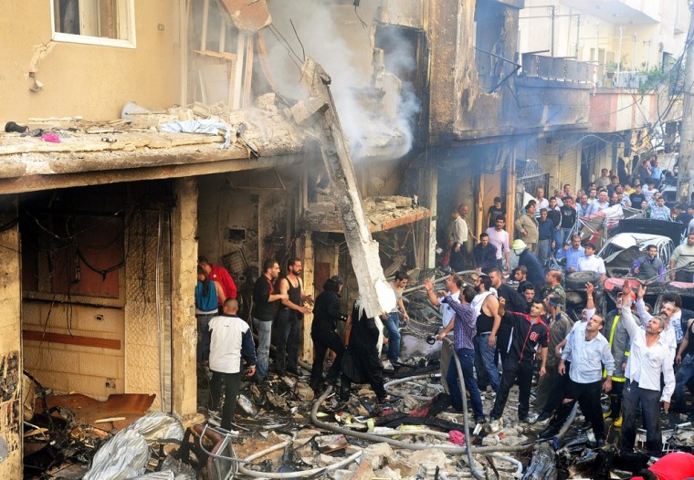 People inspecting damage at the site where a car bomb exploded in the Al Rawda area of Jaramana, southern Damascus on October 29, 2012.