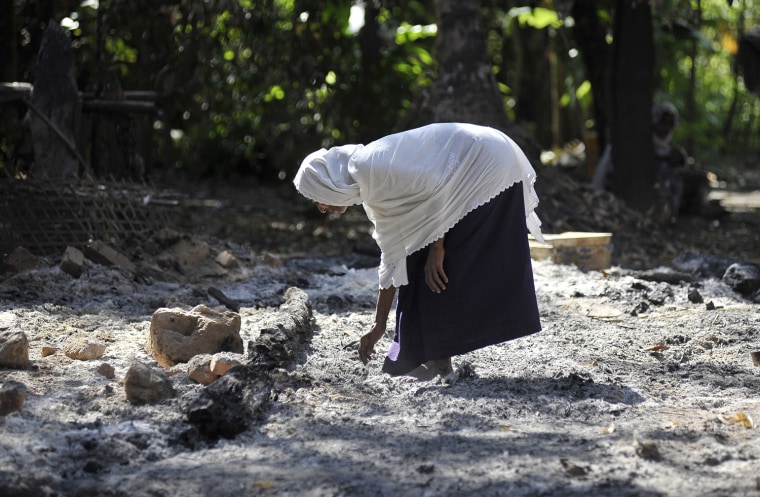 A Muslim woman collects pieces of metal from the rubble of a Muslim quarter of Pa Rein village that was burned in recent violence between Buddhist Rakhines and Muslim Rohingyas in Myauk Oo, Myanmar, Oct. 29.