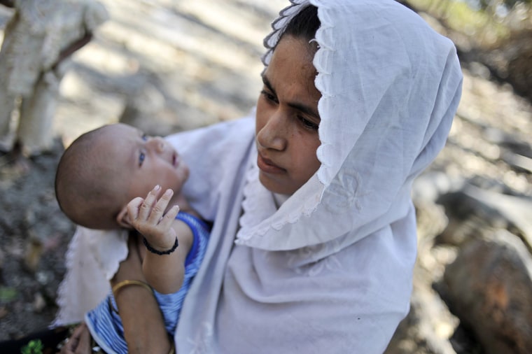 A Muslim woman holds her child in a Muslim quarter of Pa Rein village, Myauk Oo, Myanmar, Oct. 29.