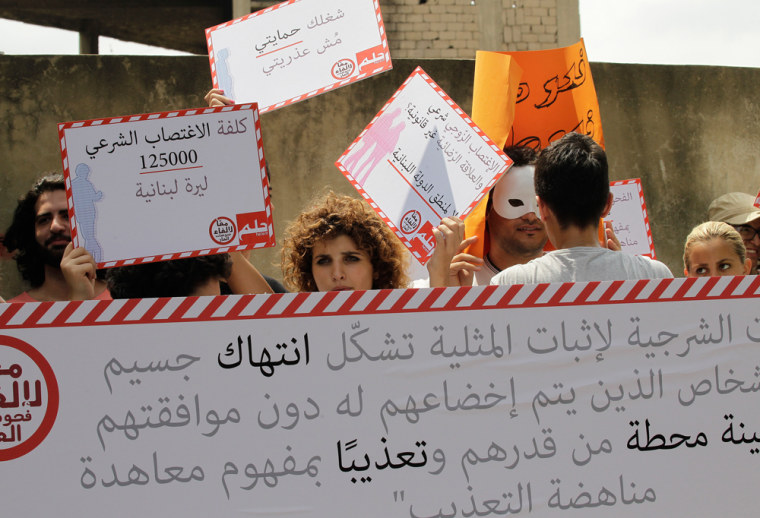 Lebanese demonstrators hold signs against