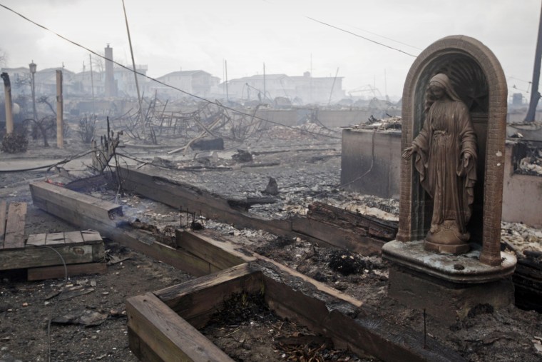 A statue of Mary is left behind after damage from a fire in Breezy Point, Queens, N.Y.
