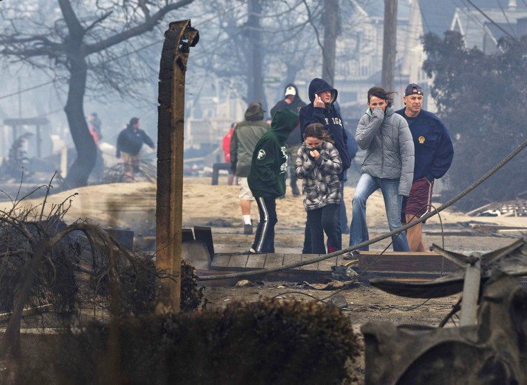 People survey the damage Tuesday to homes devastated by fire in Breezy Point, Queens.