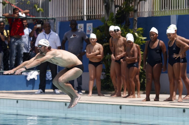 U.S. Olympic swimmer Michael Phelps gives a swimming lesson to youths during a visit at the Alemao slum complex's Olympic Village in Rio de Janeiro, Oct. 30.