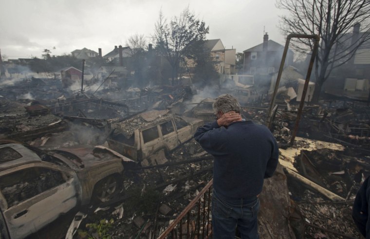 A resident looks over the remains Tuesday of burned homes in the Breezy Point neighborhood of Queens, N.Y.