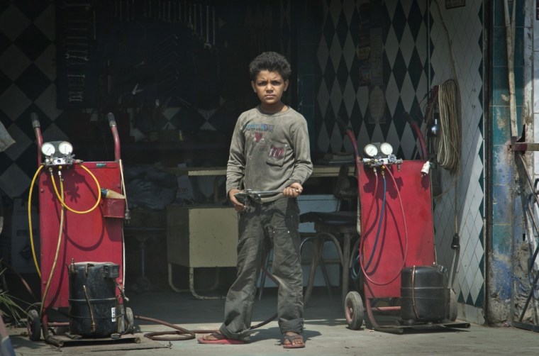 An Egyptian child stands in front of a tire repair shop where he works in Cairo, Egypt. Photo taken on Oct. 2.
