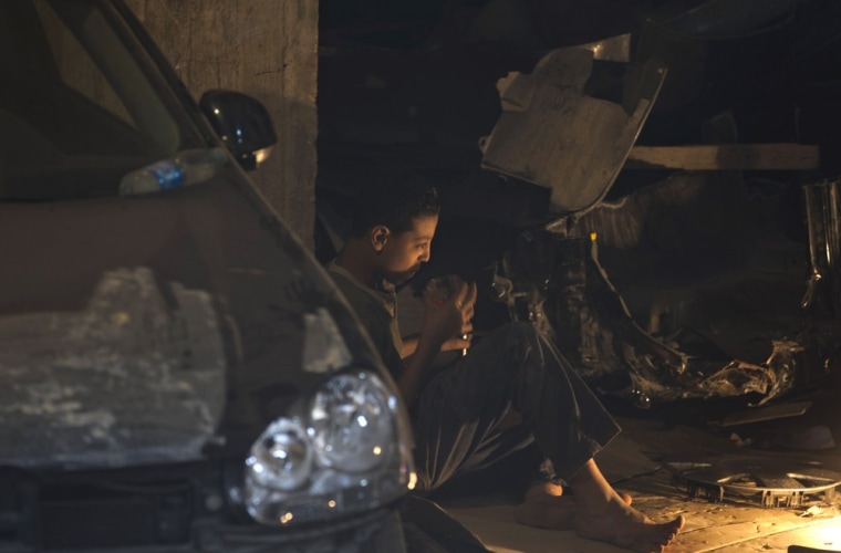 An Egyptian child takes a tea break during his work at a mechanics workshop in Cairo, Egypt. Photo captured Oct. 4.