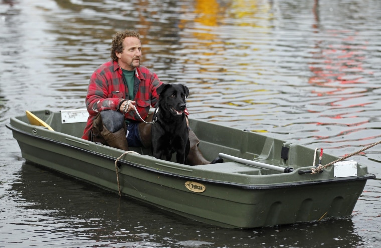Ray Cilli and his dog Woubie are rescued from flood waters brought on by Sandy in Little Ferry, N.J., on Tuesday.