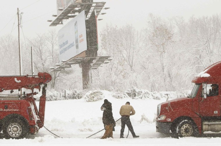 A snow-stuck freight truck is hooked up by a large tow truck in Garrett County, western Maryland on Oct. 30.