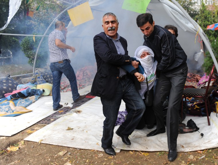 Protestors help a woman affected by tear gas used by police during clashes against Kurdish demonstrators protesting in support of a hunger strike movement by Kurdish prisoners in Istanbul, Turkey, Oct. 30.
