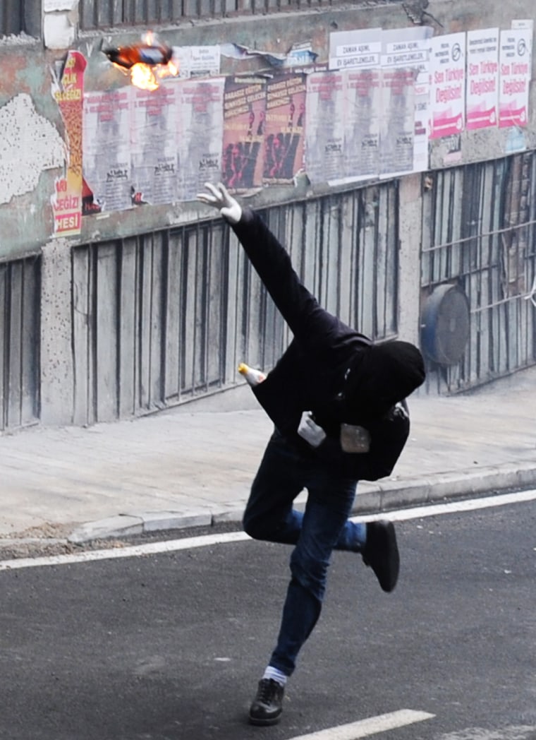 A protestor throws a fire bomb during clashes in Istanbul, Oct. 30.
