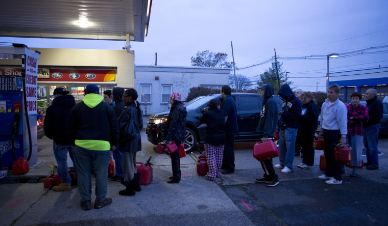 Stephanie Sikaris, of Union, N.J., with red bandana, waits in line on Oct. 30 at an Exxon station on Route 22 to fill up her gas containers to feed the generator she bought on Monday from Home Depot.