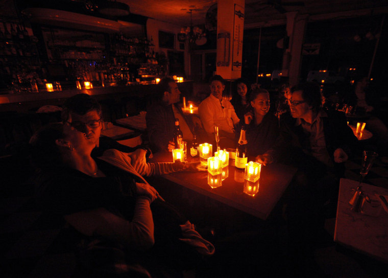 Customers and staff ride out Superstorm Sandy together by candle light at the Greenwich Village restaurant French Roast in New York, Oct. 30. New York Power Company Consolidated Edison Inc. said that it had shut off power to part of Lower Manhattan to protect electrical equipment and to allow for quicker restoration after Hurricane Sandy passes.