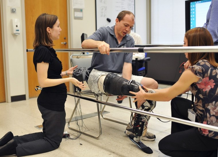 Biomedical engineer Annie Simon, left, and research prosthetist Elizabeth Halsne fit an experimental