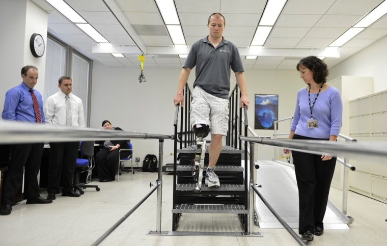 Physical therapist assistant Suzanne Finucane, right, helps Zac Vawter as he practices walking at the Rehabilitation Institute of Chicago.