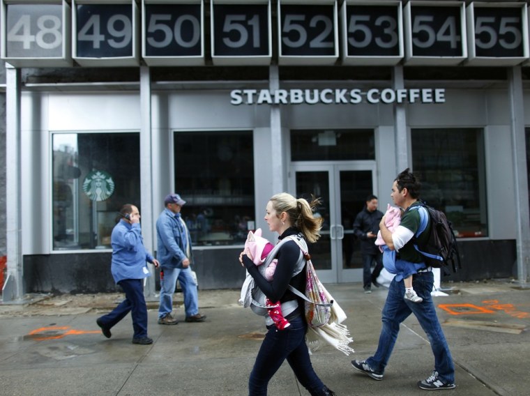 Pedestrians walk past a closed Starbucks in lower Manhattan on Tuesday in the aftermath of Hurricane Sandy.