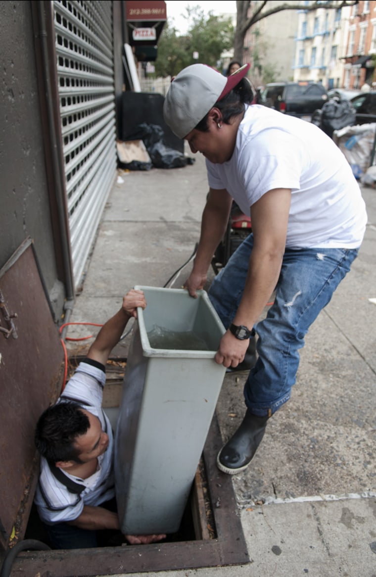 Restaurant workers remove water from the flooded basement of the 11B Express pizzeria in the East Village, New York, on Wednesday.