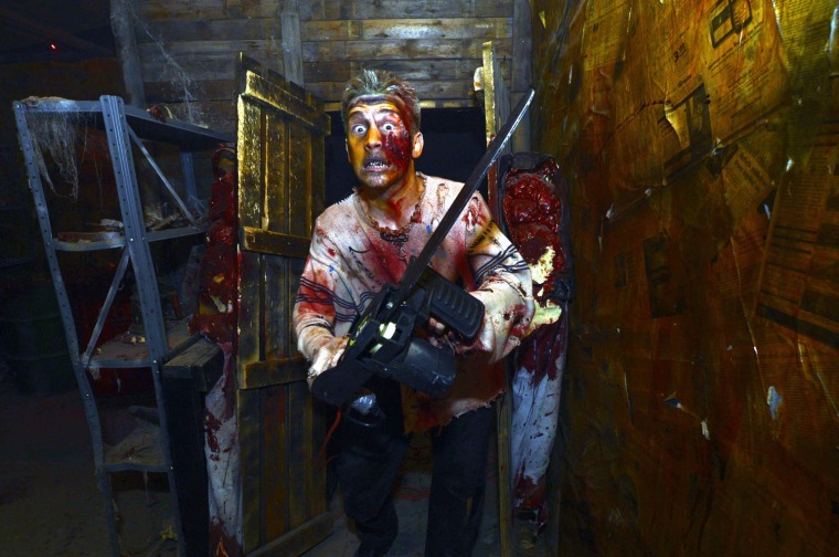 A performer of the Haunt House is scaring visitors during Halloween, in Caddo Mills, Texas on Wednesday night. Thousands of people visit haunted houses across the country each year around Halloween.