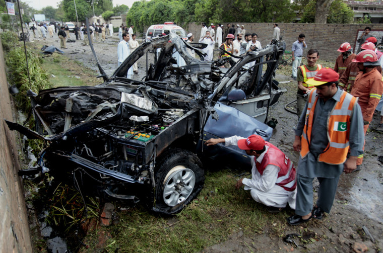 A burnt-out vehicle at the site where a suicide bomber rammed a car filled with explosives into a U.S. government vehicle in Peshawar, northwest Pakistan, on Monday.