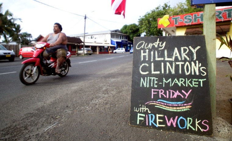 People commute past a sign advertising a night market in Avarua on the Island of Rarotonga in the Cook Islands on Thursday as Pacific Islands Forum leaders gathered to discuss issues facing the region.