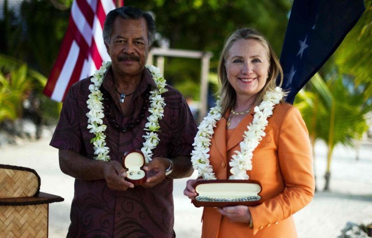 U.S. Secretary of State Hillary Clinton poses with gifts from Cook Islands' Prime Minister Henry Puna during a sustainable development and conservation event in Rarotonga on Friday.