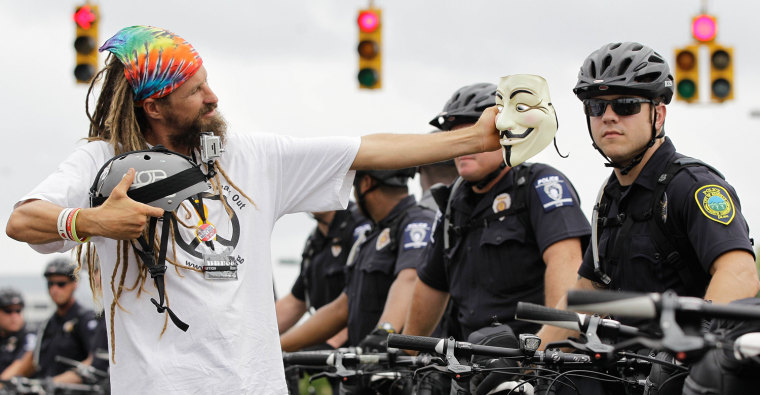 An Occupy Demonstrator takes a photo with his mask during an unscheduled protest march, on Sept. 4, in Charlotte, N.C.