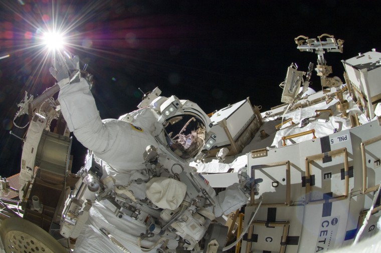 NASA's Sunita Williams appears to reach out toward the sun in a picture taken by Japan's Aki Hoshide during a Sept. 5 spacewalk at the International Space Station.