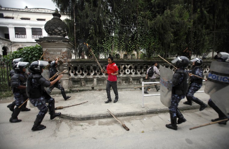 Nepalese riot police surround a student participating in a torch rally organized by various student unions in Kathmandu.