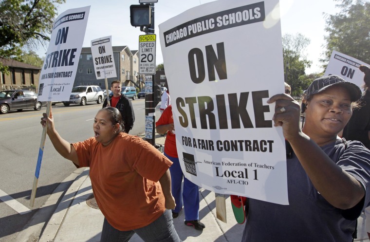 Parents of Chicago public school students, Carmen Brownlee, left, and, Latonya Williams, right, walk a picket line outside Shoop Elementary School in support of striking CPS teachers, Sept. 11, 2012.