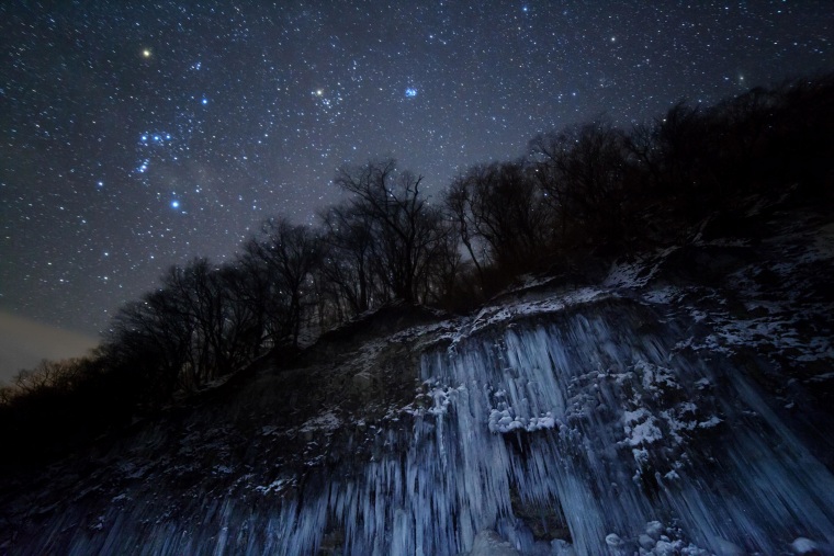 Japan's Masahiro Miyasaka won top honors in the Earth and Space category with this shot of Orion, Taurus and the Pleiades shining in the night sky above an icy landscape. The category is for photos that include