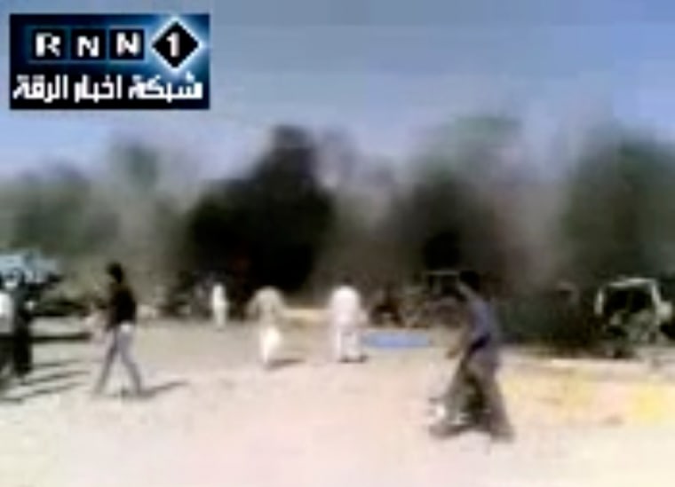 In this image taken from video obtained Thursday, people are seen after an airstrike on a gas station in Raqqa, Syria.
