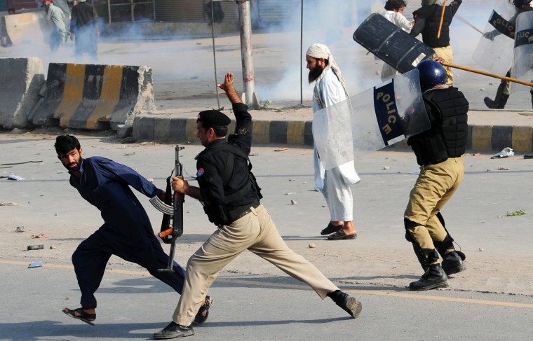 Pakistani police charge at demonstrators during a protest against an anti-Islam film in Peshawar on Sept. 21. At least 13 people died and nearly 200 were wounded in Pakistan during violent protests condemning a US-made film insulting Islam, defying a government call for only peaceful demonstrations, officials said.