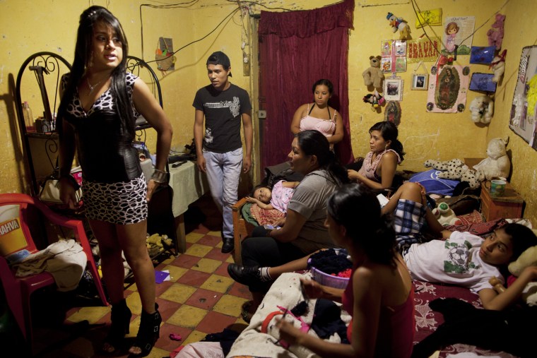 Linda Elizabeth Tylor Martinez, left, looks in a mirror as she gets ready at a friend's home before working as a sex worker in the