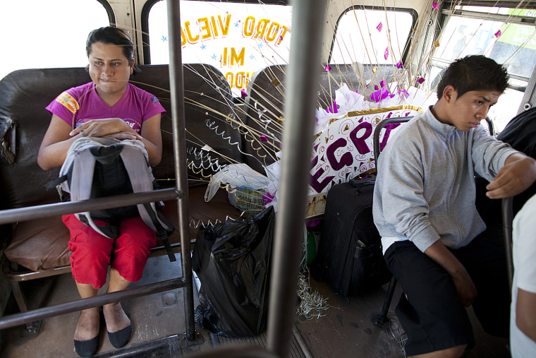 Linda Elizabeth Tylor Martinez, left, takes the bus with her costume, which she will use to compete in the Miss Night Queen beauty contest, in Guatemala City, June 15.