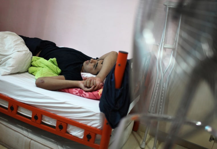 A wounded Syrian refugee lies on a bed after receiving medical treatment at the Reynhali State Hospital on Sept. 20.