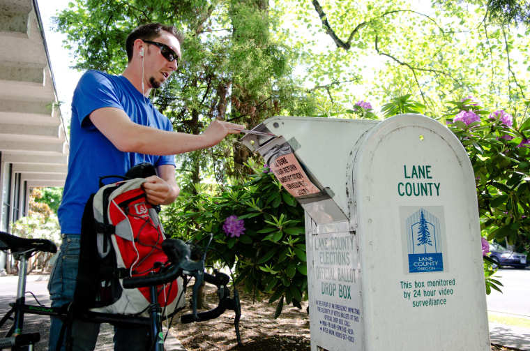 Jason Randall, 26, places his mail-in ballot in a drop box outside the Lane County Elections Office in Eugene, Ore. Although Oregon conducts all of its elections by mail, residents have the option of mailing their ballots or returning them at drop boxes located throughout the county.