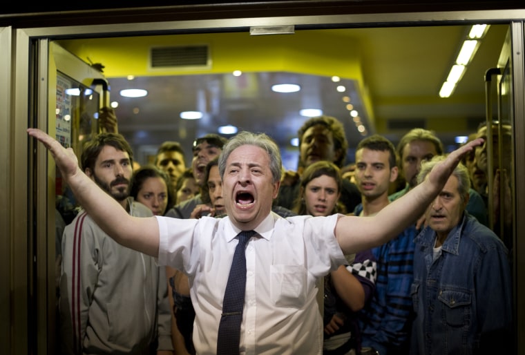 A restaurant owner shouts, with his clients behind him, at demonstrators to stop throwing stones at his restaurant, after a protest around the Spanish parliament in Madrid, Sept. 25.
