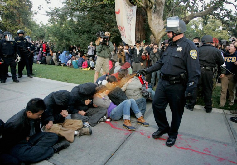 A UC-Davis police officer pepper-sprays students during their sit-in at an