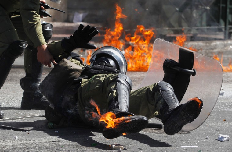 A riot policeman reacts after he was hit by a petrol bomb thrown by protesters during a nationwide general strike in Athens on Sept. 26. Police clashed with protesters hurling petrol bombs and bottles in central Athens Wednesday after an anti-government rally called as part of a general strike in Greece turned violent.