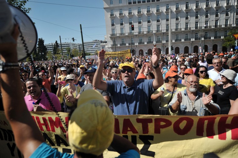 Protestors chant slogans in front of the parliament on September 26, 2012 during a 24-hours general strike in Athens. Police in Athens clashed with hooded youths throwing firebombs on the sidelines of a large demonstration against a new round of austerity cuts. AFP PHOTO / LOUISA GOULIAMAKILOUISA GOULIAMAKI/AFP/GettyImages